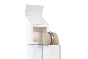 Luxury watch box displayed with a watch placed in front for an elegant presentation.