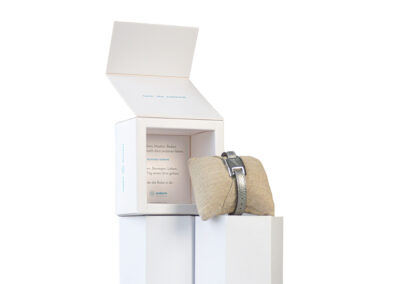 a white box with a belt and a pillow